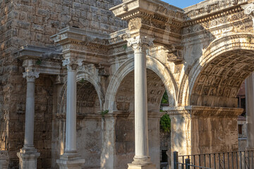 Obraz premium The Arch of ancient times. The famous gate, built in honor of the ancient Roman emperor. The Arc de Triomphe in the Kaleici area. Hadrian's Gate in Antalya. The arch is decorated with carved patterns.