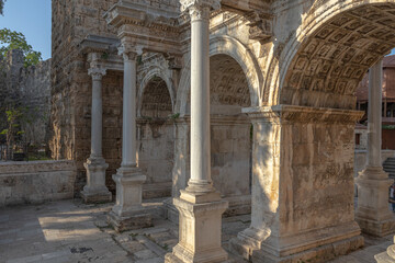 Fototapeta premium The Arch of ancient times. The famous gate, built in honor of the ancient Roman emperor. The Arc de Triomphe in the Kaleici area. Hadrian's Gate in Antalya. The arch is decorated with carved patterns.