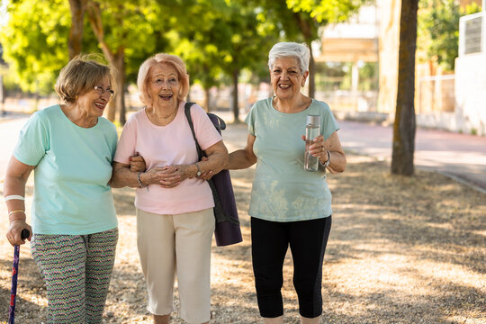 Elderly women smiling and walking in the park after exercising