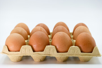 Fresh brown eggs in a carton ready for cooking or baking in a home kitchen setting