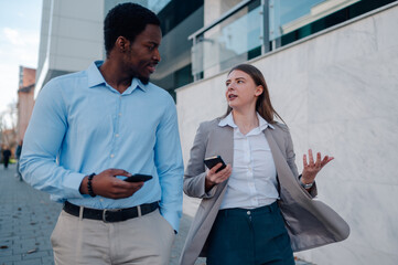 Businesspeople walking and talking about work outside office building