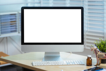 A clean, organized veterinary clinic workspace featuring a desktop computer with a blank screen, anatomical dog model, stethoscope, medicine bottles, calculator, and document shelves