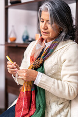 Senior woman knitting at home, concentrating on her craft