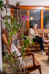 Senior woman relaxing with tea and book in peaceful home