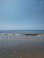 Beautiful beach background. Tropical beach view with soft sand and blue sea and blue sky and fluffy clouds.
