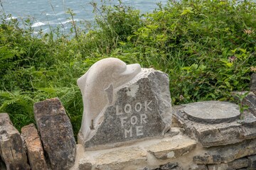 Dolphin sculpture at Durlston Country Park Swanage Dorset England with the sea in the background
