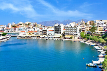 Obraz premium The lake Voulismeni in Agios Nikolaos, a picturesque coastal town with colorful buildings around the port in the eastern part of the island Crete, Greece