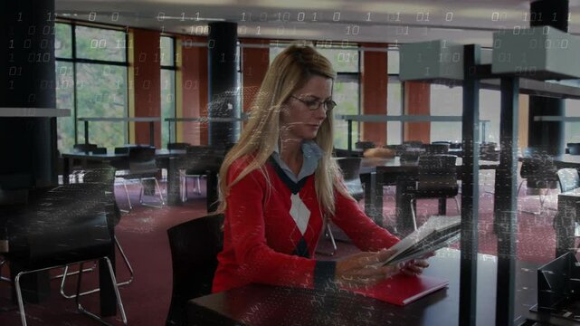 Woman placing red binder on library table and scanning printed pages for academic review