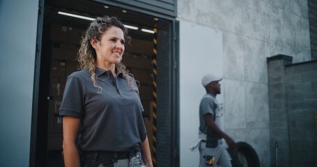 Outside of Logistics Retail Warehouse: Female Worker Giving Cardboard Box with Online Orders, E-Commerce Goods to Unrecognizable Colleague for Delivery. Working in Delivery Service, Storage Facility.