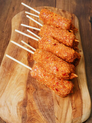 Pile of fancy kebabs on wooden sticks on wooden cutting board. Tasty meal made from fine beef or...
