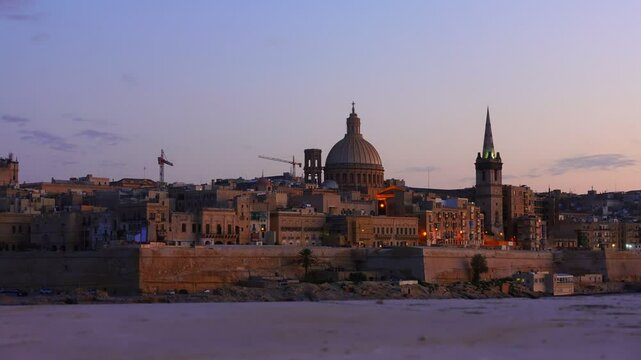 beautiful view of city of Valletta with Basilica Our Lady Mount Carmel in Marsamxett Harbour, Malta, Europe, sunset timelapse