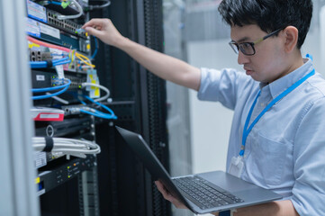 Computer engineer is setting up network in server room,Systems Maintenance Technician,Male engineer...