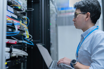 Computer engineer is setting up network in server room,Systems Maintenance Technician,Male engineer...