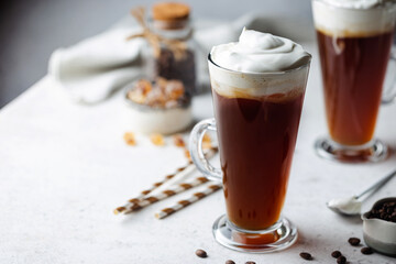 Iced coffee in a tall glasses with cream poured over