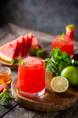 Refreshing cold summer watermelon drink in glasses with slices of watermelon and lime