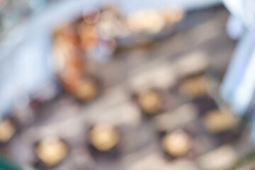 Blurry abstract view of indoor cafe with tables and chairs in bright natural light.