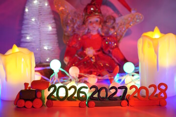 Christmas train with numbers 2026, 2027, 2028 and decorative candles. Bright red background.
