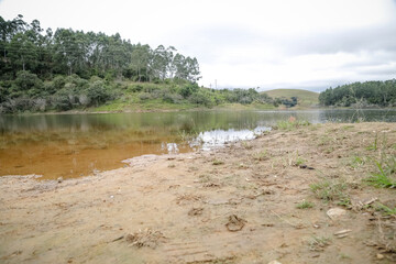 Foto de uma ponte cruzando uma represa em meio à natureza. As águas calmas refletem a estrutura e a vegetação ao redor, compondo uma cena tranquila e harmônica. Ideal para temas de infraestrutura, mei