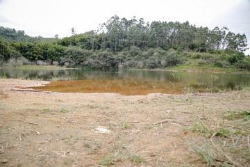 Foto de uma ponte cruzando uma represa em meio à natureza. As águas calmas refletem a estrutura e a vegetação ao redor, compondo uma cena tranquila e harmônica. Ideal para temas de infraestrutura, mei
