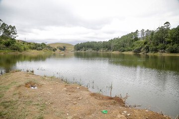 Foto de uma ponte cruzando uma represa em meio à natureza. As águas calmas refletem a estrutura e a vegetação ao redor, compondo uma cena tranquila e harmônica. Ideal para temas de infraestrutura, mei