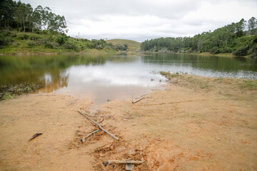 Foto de uma ponte cruzando uma represa em meio à natureza. As águas calmas refletem a estrutura e a vegetação ao redor, compondo uma cena tranquila e harmônica. Ideal para temas de infraestrutura, mei
