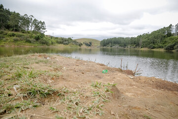 Foto de uma ponte cruzando uma represa em meio à natureza. As águas calmas refletem a estrutura e a vegetação ao redor, compondo uma cena tranquila e harmônica. Ideal para temas de infraestrutura, mei