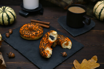 autumn still life with donuts, a cup of coffee, pumpkins and leaves on the table