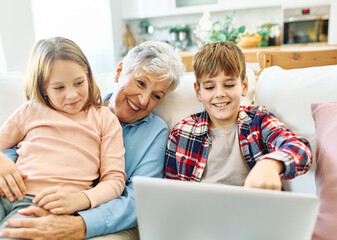 Family grandmother and grandchildren granddaughter and grandson, girl and boy, having fun using...