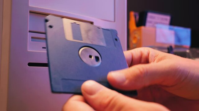Floppy disc FDD close up, Using diskette for old PC computer macro. Archive programme or Music recorder, playing retro computer games. Vintage device for office, obsolete technology. 