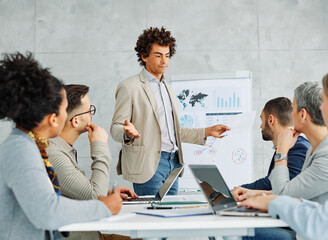 Group of young business people having a meeting or presentation and seminar with whiteboard in the...
