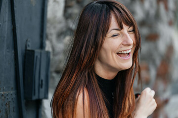 Young caucasian female laughing outdoors with long hair