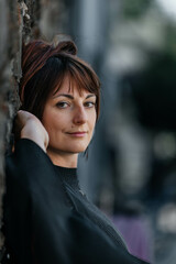Confident young caucasian female with short hair leaning against wall