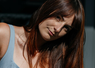 Young caucasian female with long brown hair in sunlit setting