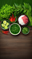 Overhead shot of fresh Thai ingredients including herbs, chilis, limes and tuna arranged on dark wood surface with banana leaf, ready for a culinary creation.