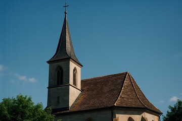 Fototapeta premium Historic church steeple and tiled roof against a clear blue sky