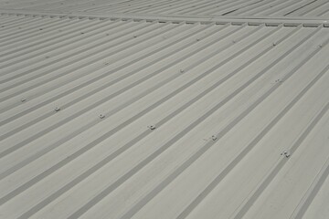 Installation of a specialized ridge cap designed specifically for industrial white sandwich panels. The ridge cap is attached with rivets and sealant to ensure strength and water resistance.
