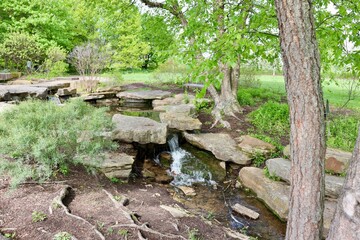 The flowing small waterfall in the park.