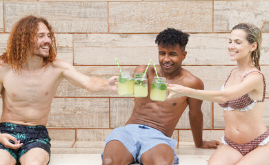 Three friends are enjoying refreshing lemonade by the pool during summer