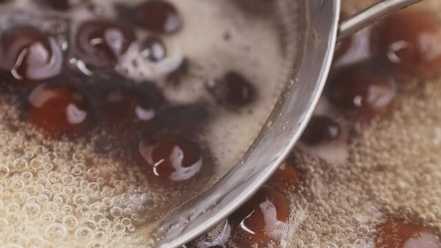Cooking, boiling brown sugar flavor tapioca pearl balls, chinese food, ingredient of bubble tea, preparing food and drink, close up, recipe cookbook steps design concept.