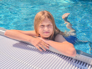 A young child is joyfully enjoying some delightful poolside relaxation on a sunny day
