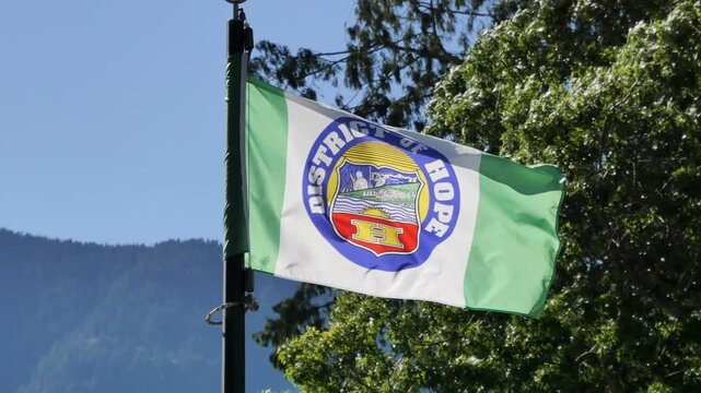 District of Hope flag waving in the wind during a summer season in Hope, British Columbia, Canada