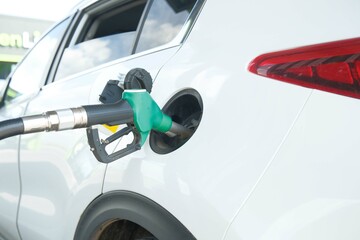 Refueling a White SUV at a Gas Station, ensuring the vehicle is powered for the road ahead