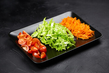 Freshly chopped vegetables including vibrant tomatoes, crisp lettuce, and shredded carrots arranged...