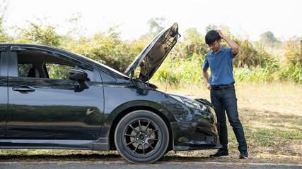 Mechanic or driver providing roadside assistance by changing a flat tire and performing minor...