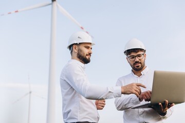 Engineers working on a laptop in a wind turbine power plant