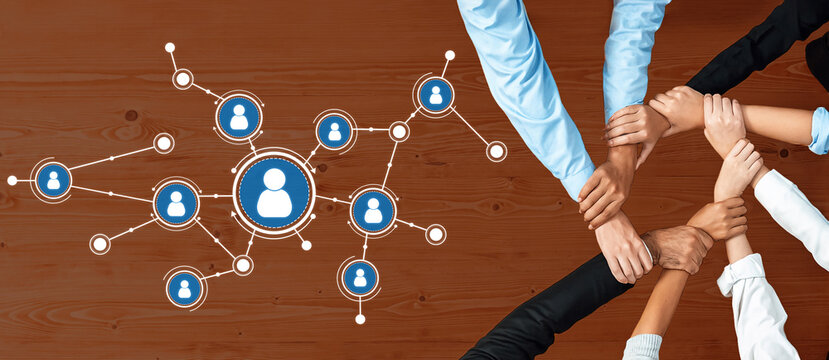 A dynamic image showing diverse hands coming together around a network concept, symbolizing teamwork and communication in a collaborative environment on a wooden backdrop. Amity