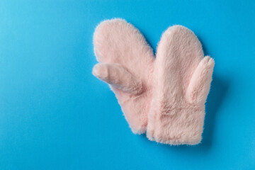 Soft Pink Fuzzy Mittens on Blue Background Highlight Cozy Winter Accessories