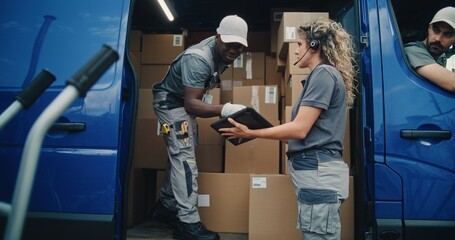 Outside of Logistics Retail Warehouse: African American Worker Unloading Cardboard Boxes with...