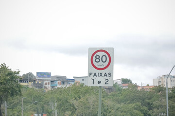 Sinalização rodoviária com limites de velocidade distintos para veículos leves (80 km/h) e pesados (60 km/h), em estrada brasileira. Ideal para temas de trânsito, segurança viária e transporte.