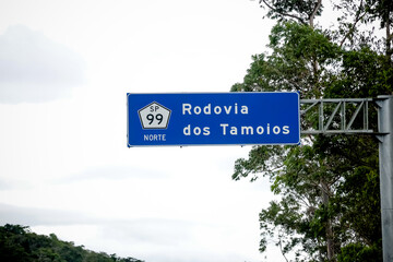 Sinalização rodoviária indicando pedágio a 1 km com opção de cobrança automática à direita. Foto ideal para temas de mobilidade, transporte rodoviário e infraestrutura no Brasil.